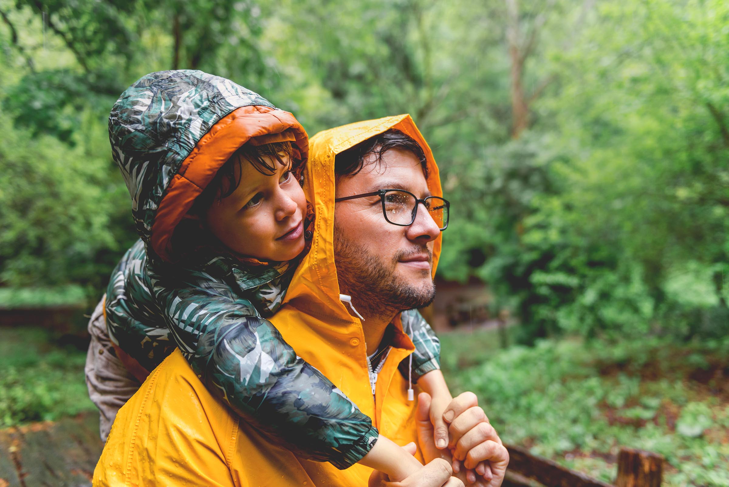 dad with a boy on his shoulders in the rain