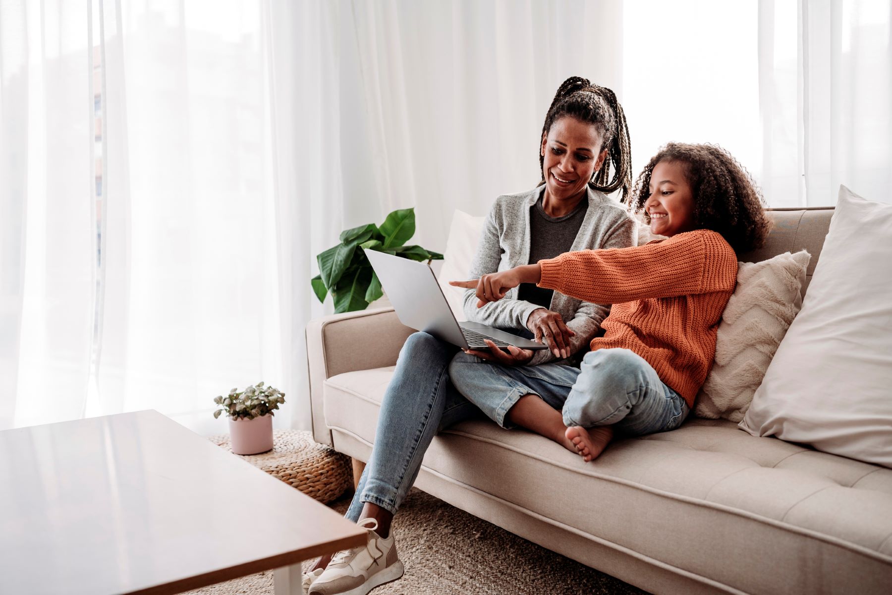 smiling girl and her mom looking at a computer