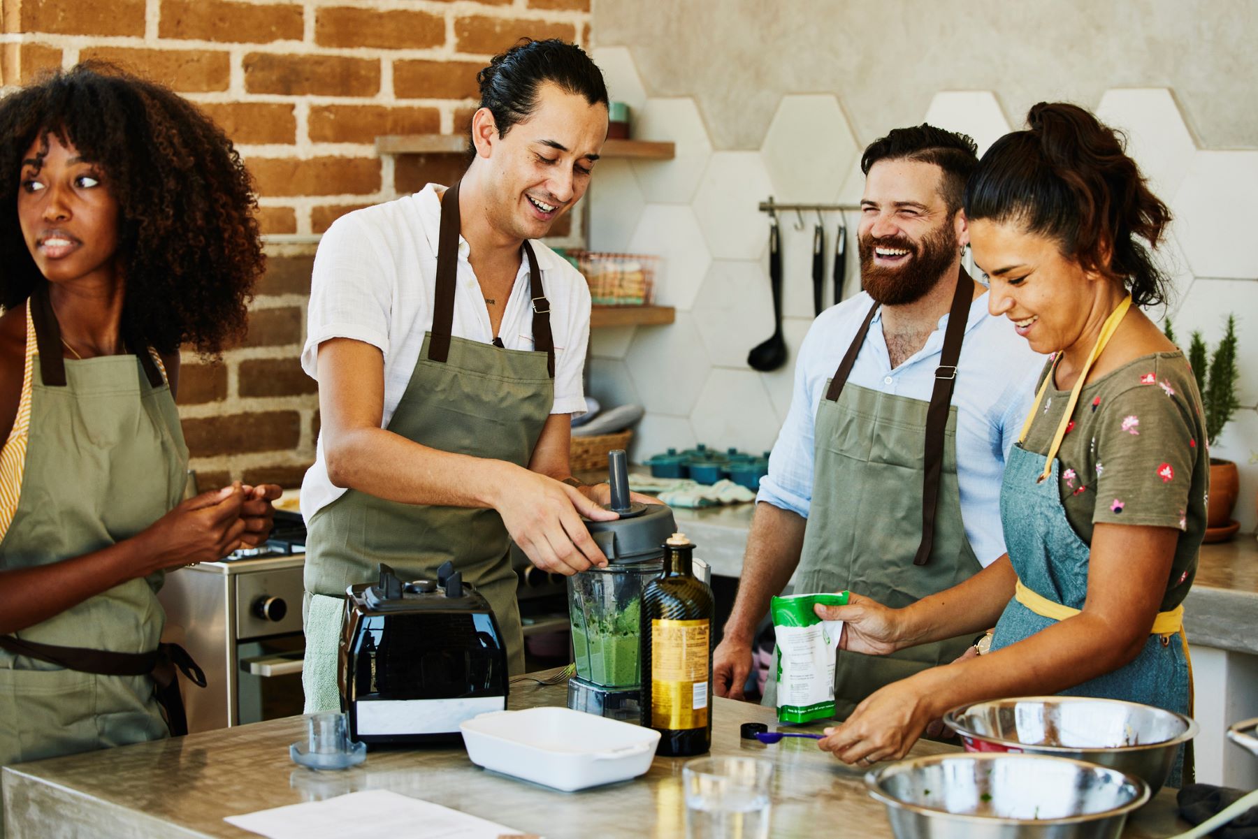 diverse group of adults laughing and talking in a cooking class