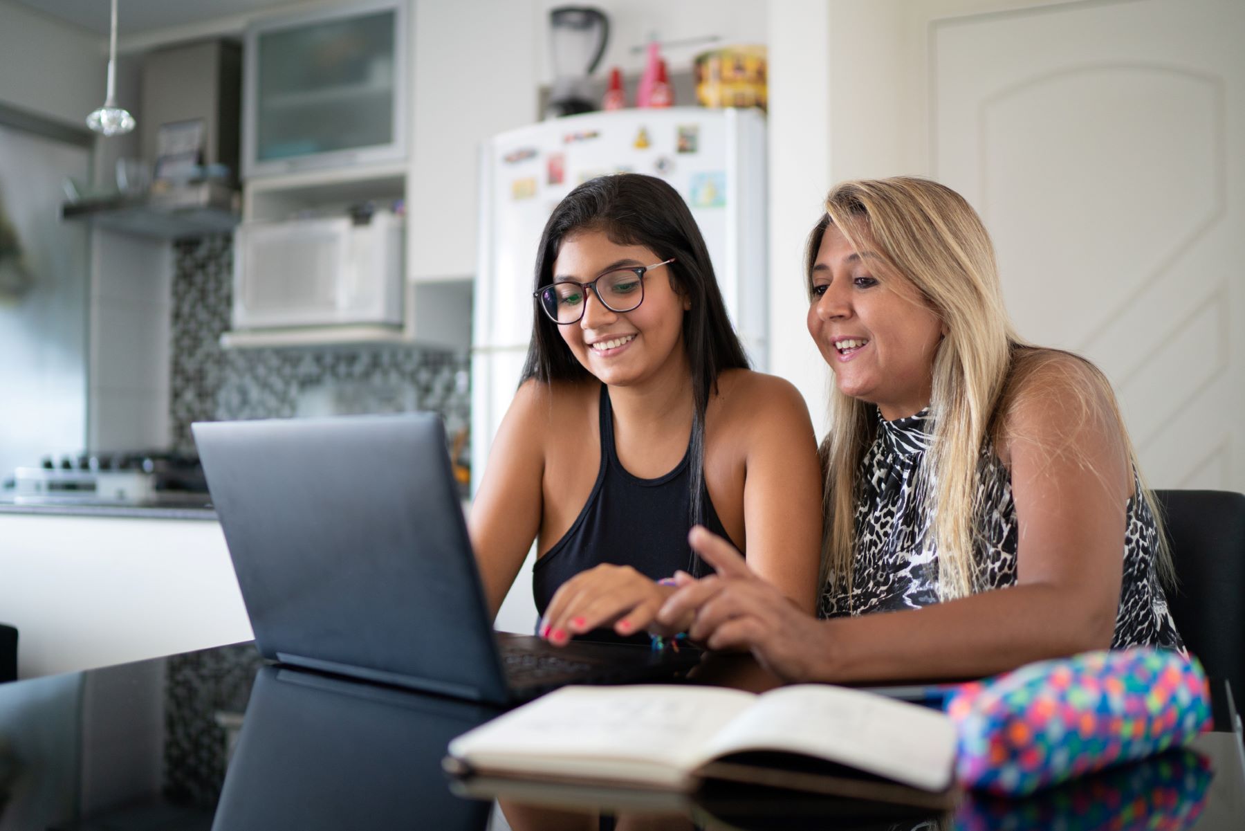 mom and smiling teen at the computer