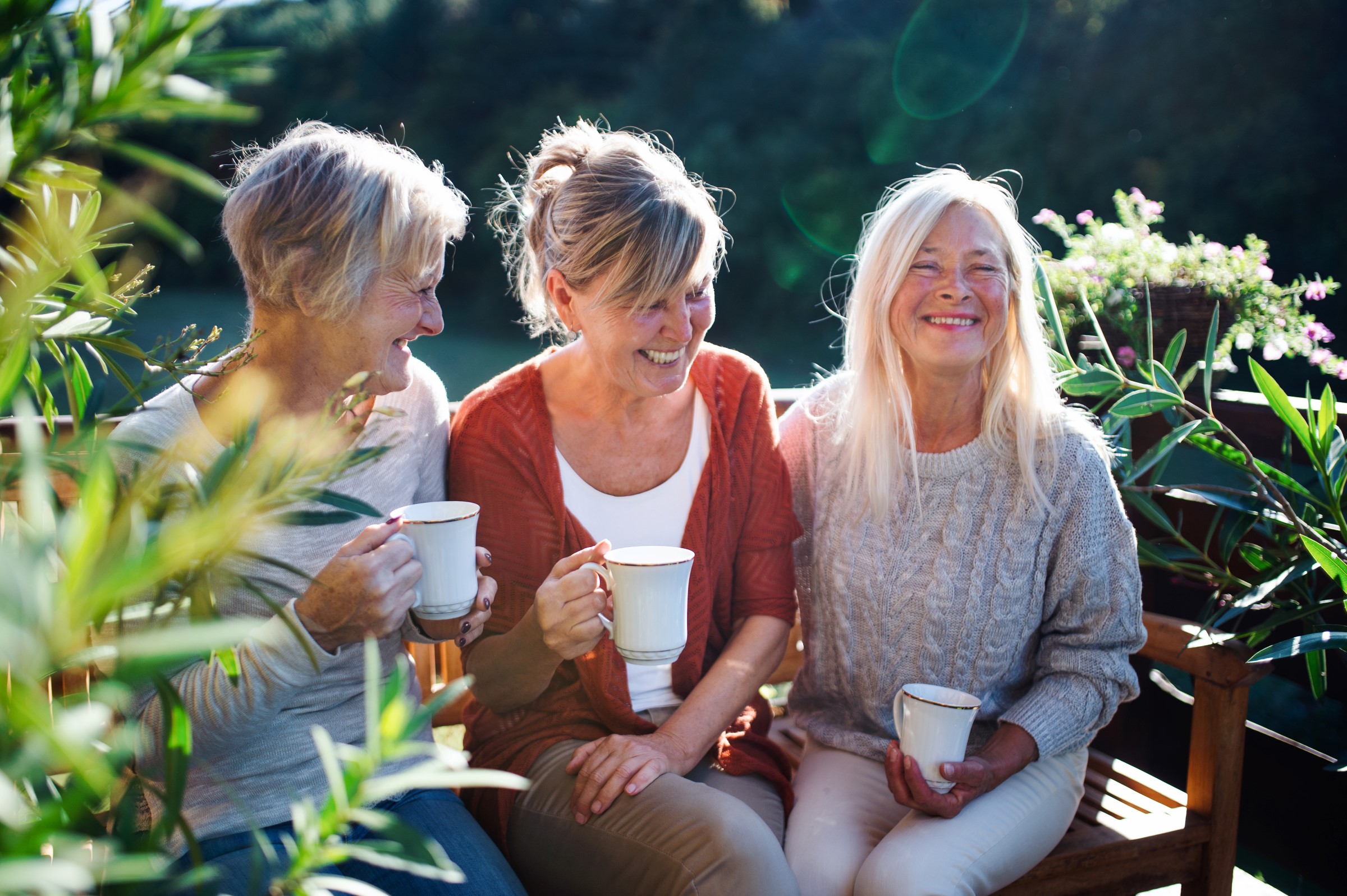 Three women with coffee talking and smiling