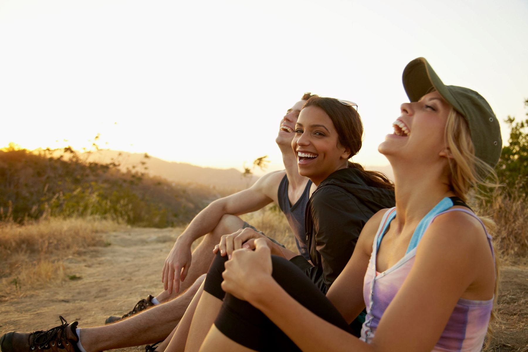 three smiling women enjoying a sunset